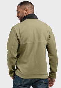 Grüne Fleecejacke mit einem schwarzen Kragen; hat eine glatte Textur, einen lässigen Schnitt, eingesetzte Ärmel und eine sichtbare Naht auf dem Rücken.