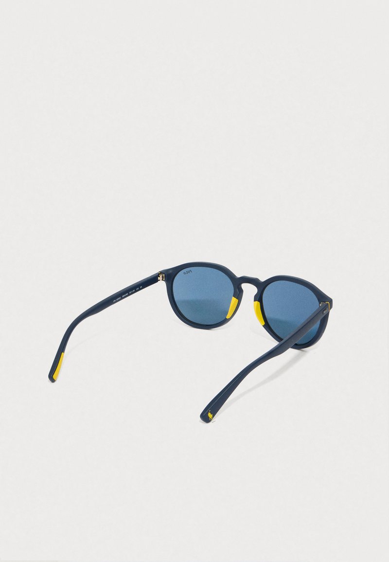 Round sunglasses with a matte navy frame, blue lenses, and yellow accents on the temples. Sleek design with curved arms, lightweight material.