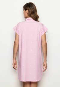 Abito camicia rosa con una leggera texture a righe e pois bianchi. Presenta maniche corte e un colletto, con spacchi laterali sull'orlo.
