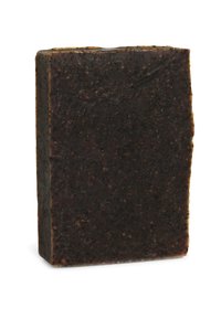 Massieve zwarte zeepbar met een rechthoekige vorm, voorzien van een grove textuur en kleine zichtbare deeltjes over het oppervlak.