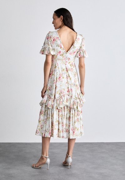 Abito midi floreale con schiena a V, maniche corte a volant e orlo a strati con volant. Base bianca con motivi floreali rosa e verdi.