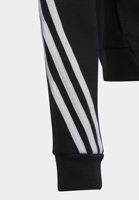 Czarny sweatshirt z białym wzorem trzech pasków wzdłuż rękawa. Posiada ściągacz w mankiecie i miękką fakturę. Prosta, sportowa estetyka.