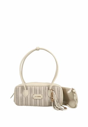 Sac à main tissé beige avec doubles poignées, breloque pompon dorée et compartiment principal ouvert avec fermeture éclair sur fond blanc.