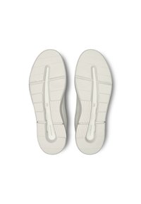 Suole in gomma bianca con un motivo testurizzato, dotate di scanalature e rinforzi per una buona aderenza e flessibilità. Design e forma minimalista.