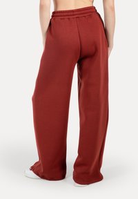 Kalhoty z bavlněné směsi, s vysokým pasem a širokými nohavicemi v tmavě červené barvě. Mají elastický pas a měkkou texturu, s volným a uvolněným střihem.