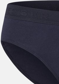 Slip in cotone blu navy con elastico nero testurizzato e lettering in rilievo. Tessuto liscio e bordi cuciti.