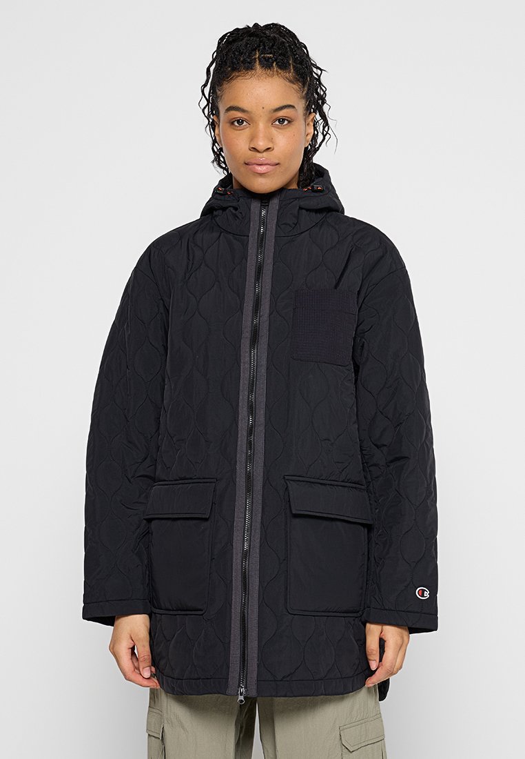 Schwarze gesteppte Jacke mit durchgehendem Reißverschluss, zwei großen Taschen und Kapuze. Verfügt über ein strukturiertes Patch auf der Brust und dezente Logodetails.