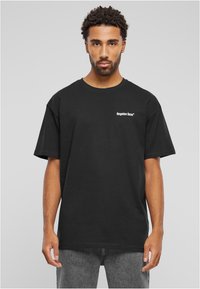 Juodas medvilnės marškinėliai su apvalia iškirpte ir trumpomis rankovėmis. Kairėje krūtinės pusėje yra baltas užrašas "užmiršti veidai". Paprastas dizainas, laisvas siluetas.