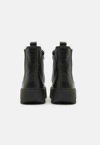Black leather ankle boots with a smooth finish, featuring side zippers, a rounded toe, and a chunky, textured sole.