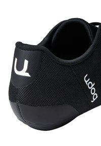 Scarpa sportiva nera con tomaia in rete texturizzata, tacco arrotondato e dettaglio del logo bianco sul retro. Suola in gomma liscia per una maggiore aderenza.