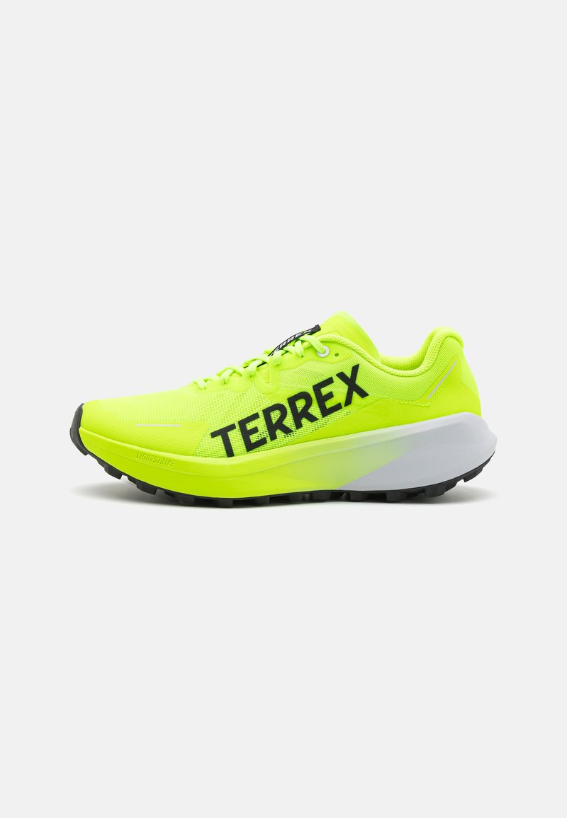 Neon geltonos bėgimo bateliai su tinklelio viršumi, juodu "TERREX" logotipu ir kontūruota balta tarpine. Savybė - tvirta juoda padas, užtikrinantis sukibimą.