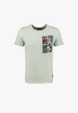 Camiseta de manga corta de color verde claro con un gráfico de cuatro paneles que muestra un cráneo con una corona de flores en el lado izquierdo del pecho.