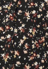 Tessuto nero con una superficie texture che presenta un motivo floreale in tonalità di rosso, rosa, giallo e bianco.