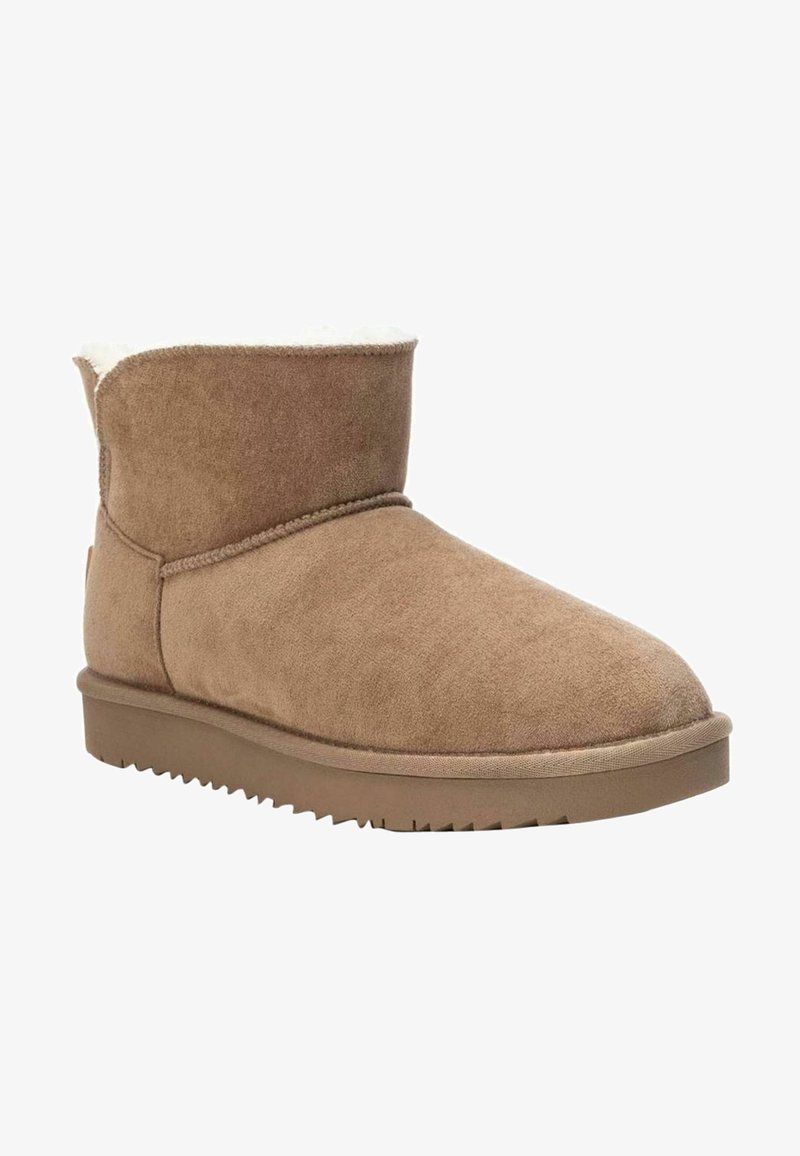 Bottine marron en daim avec doublure en shearling, semelle en caoutchouc plate et bout arrondi, conçue pour le confort par temps froid.