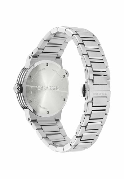 Reloj de pulsera Ferragamo de acero inoxidable plateado visto desde la parte trasera, mostrando el nombre de la marca y la pulsera de eslabones de metal con cierre.
