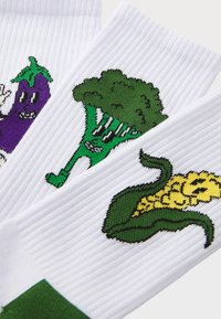 Chaussettes blanches avec une texture côtelée, ornées de broderies de brocoli vert, d'aubergine violette et de maïs jaune.