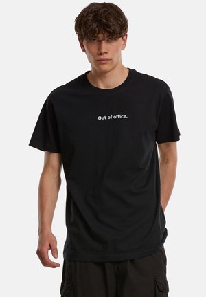 Čierne bavlnené tričko s krátkymi rukávmi a okrúhlym výstrihom. Na prednej strane je vytlačený biely nápis „Out of office.“ Voľný strih.