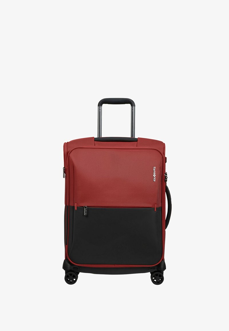 Two-tone red and black soft suitcase with four wheels, extendable handle, side grip handle, front zipper pocket, and Samsonite logo on front.