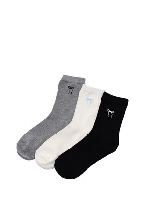 Trzy skarpety sięgające połowy łydki w kolorach szarym, białym i czarnym, każda z małym haftowanym wzorem kokardki w pobliżu mankietu.