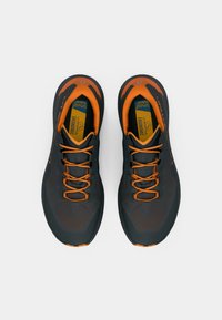 Černé a oranžové sportovní boty s síťovinovým svrškem, strukturovanými detaily a silnou podrážkou. Vybavené oranžovými tkaničkami a ergonomickými stélkami.