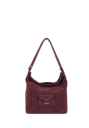 Sac d'épaule en daim rouge foncé, doux, avec une large bandoulière et une petite poche avant étiquetée "Lancaster Paris" sur fond blanc.