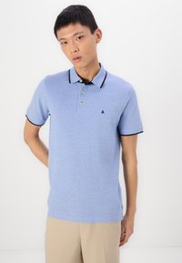 Light blue polo shirt with short sleeves, contrasting black collar and sleeve trims, three-button placket, and a small logo on the chest.