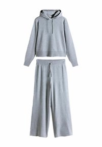 Conjunto de ropa de descanso gris que incluye un suéter con capucha y dobladillo acanalado, y pantalones de pierna ancha con cintura ajustable con cordón, en una textura suave.