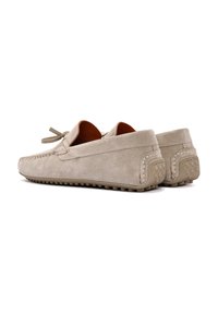 Beige Wildleder Slipper mit abgerundeter Zehenpartie, auffälligen Nähten, Lederfutter und gummierter Spitzensohle. Mit einem Schnürungsdetail.