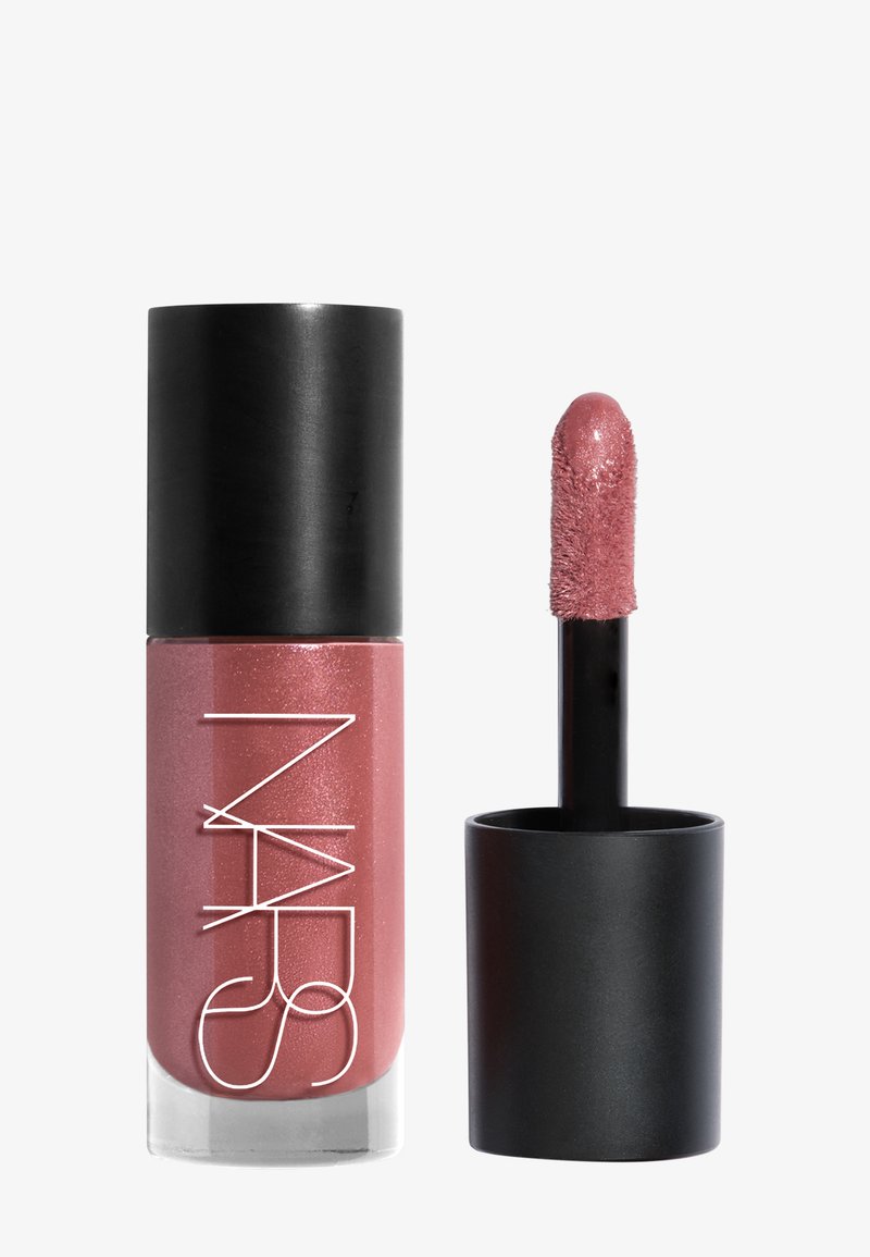 Tube de rouge à lèvres liquide rose scintillant avec un capuchon noir et un applicateur en baguette recouvert de la même couleur, ouvert et posé côte à côte.