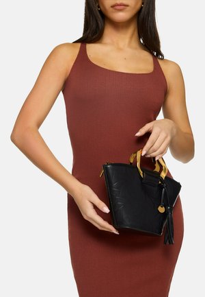 Black leather handbag with a geometric pattern, gold hardware, and a tassel accent. The bag has short handles and a zip closure.