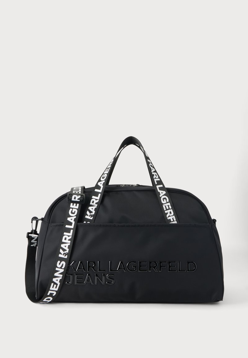 Μαύρη δερμάτινη τσάντα τύπου duffel Karl Lagerfeld με διπλές λαβές και ρυθμιζόμενο ιμάντα ώμου με λογότυπο σε ουδέτερο φόντο.