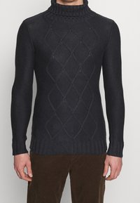 Maglione lavorato a maglia blu navy con colletto alto a coste, caratterizzato da un motivo a diamante testurizzato e una struttura leggermente aderente. Realizzato in misto lana.