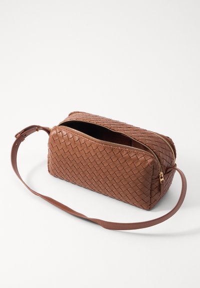 Brown, woven leather bag with a rectangular shape and a single shoulder strap. Features dual zip closures and a smooth interior lining.
