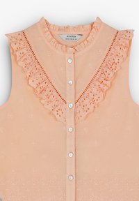 Pfirsichfarbene ärmellose Bluse mit kunstvoller Blumenstickerei, Rüschensaum und Knopfverschluss. Mit dekorativem Spitzenbesatz an der Vorderseite.