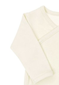 Kremowa bawełniana bluzka z długim rękawem o kopertowym kroju. Charakteryzuje się miękką fakturą, starannym przeszyciem i zaokrąglonym dekoltem.