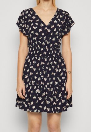 Merenqué dress with short flutter sleeves and a V-neck. Features a fitted waist with an elastic band and floral patterns throughout.