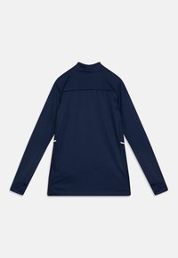 Marineblaues Langarmoberteil aus glattem Stoff; verfügt über einen hohen Kragen, Seitenschlitze und weiße Akzente nahe Saum und Schultern.