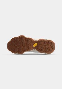 Shoe sole featuring a textured brown rubber outsole with circular grips and grooves, highlighting the Vibram logo in yellow.