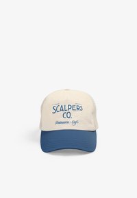 Gorra de camionero con una parte frontal color crema y visera azul, que presenta el texto "SCALPERS CO. Patisserie-Café" en una fuente azul bold en la parte delantera.
