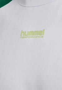 Biała sportowa koszulka z tkaniny z jasnozielonym logo "hummel PERFORMANCE" na piersi przy zaokrąglonym dekolcie.