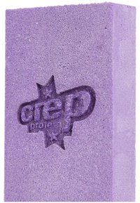 Esponja de limpieza morada con una textura rugosa, que presenta un logo en relieve. Forma rectangular con bordes suaves y un color uniforme en toda su superficie.