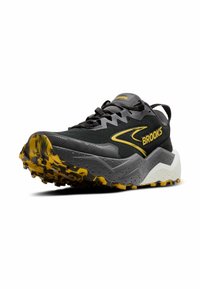Zwarte en grijze trailrunning schoenen met gele accenten, een gestructureerde bovenkant en een robuuste buitenzool met een multidirectioneel loopprofiel.