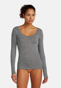 Maglietta a maniche lunghe in grigio heather, con un ampio scollo a barchetta e design aderente. Realizzata in materiale morbido e elasticizzato con costruzione senza cuciture.