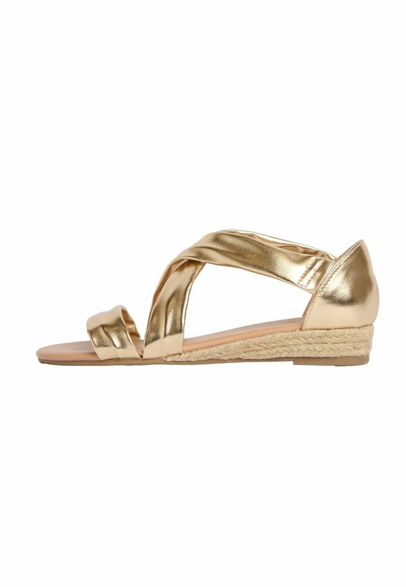 Kultainen metallinen espadrille-sandaali, jossa on ristikkäiset hihnat, pehmeä pohja ja punottu juuttipohjallinen korko. Sileä pinta, avonainen varvasmuoto.