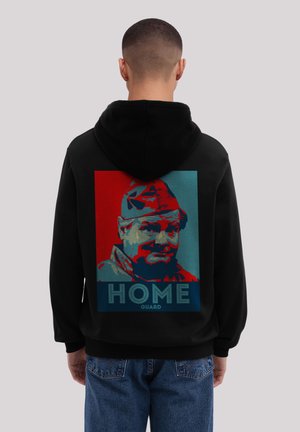 Black hoodie featuring a graphic on the back with a colorful portrait and the text "HOME GUARD" in bold letters. Soft fabric, relaxed fit.