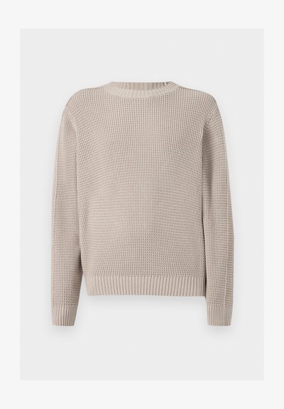 Pull beige à manches longues en maille avec une texture gaufrée, col rond, poignets et bas côtelés sur fond uni.