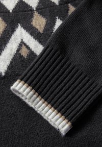 Svart tröja med geometriska mönster i vitt och brunt. Ribbad mudd med beige, vita och bruna ränder. Mjuk textur.