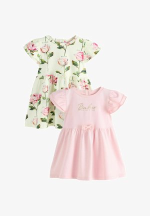 To kjoler: den ene med et blomstermønster i creme og pink, den anden ensfarvet pink med en sløjfe og diskret trykt branding. Begge har korte ærmer.