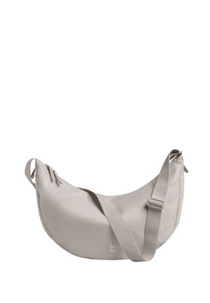 Hellgraue, sichelförmige Schultertasche mit verstellbarem Riemen, Reißverschluss und "GOT BAG"-Logo nahe der unteren Mitte.