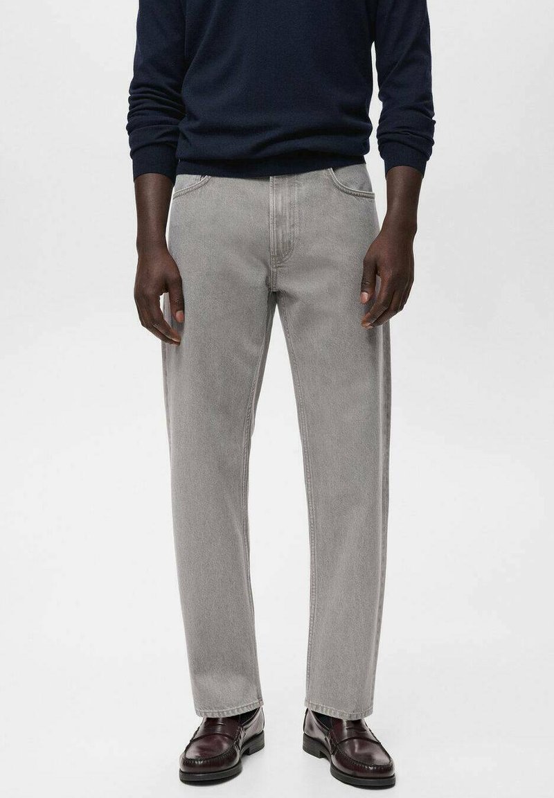 Jeans rectos de mezclilla gris con dos bolsillos frontales, costuras sutiles y una cintura clásica. Combinados con zapatos oscuros.